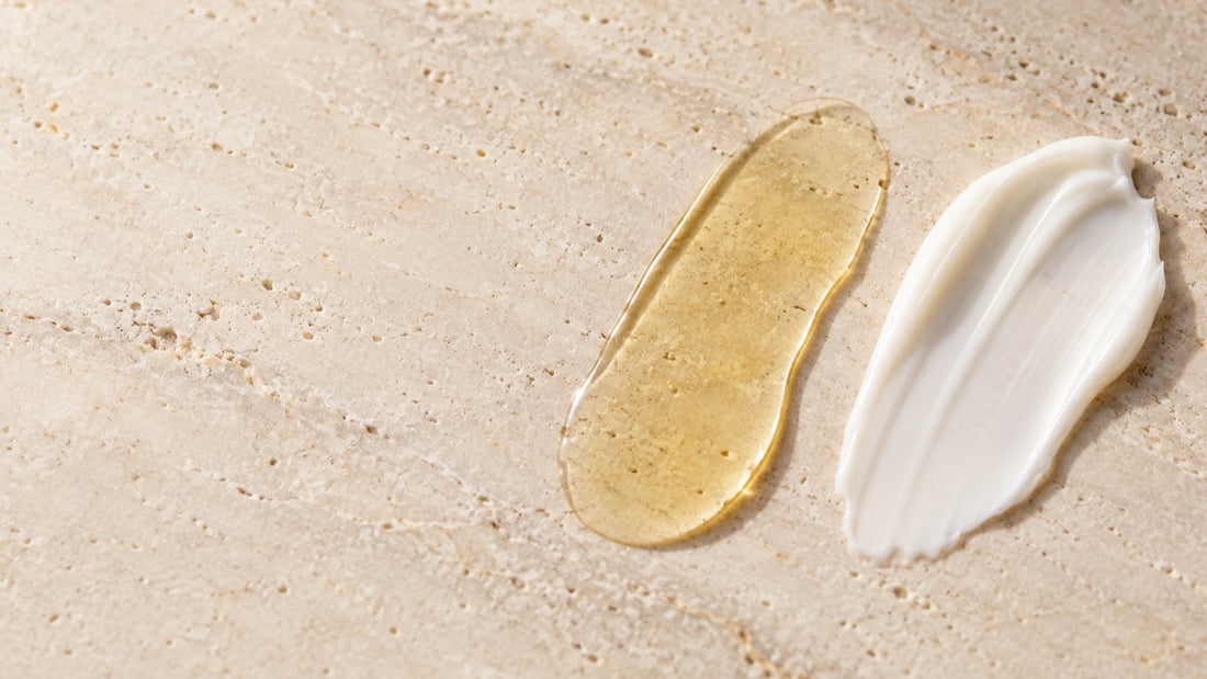 Golden body oil and white lotion textures compared side by side on pale stone